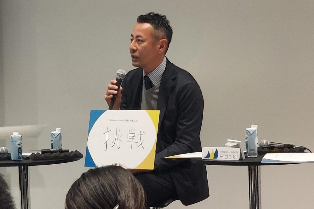 「挑戦」と書いたボードを説明する当社立澤の写真